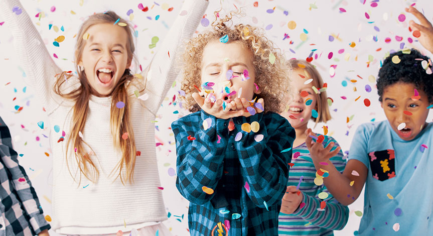 Happy group of kids having fun during birthday party with confetti
