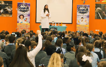 Mad Science instructor in front of group of school kids performing a mad science experiment 